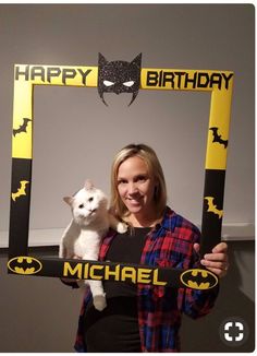 a woman holding a cat in front of a happy birthday photo frame with the word michael written on it