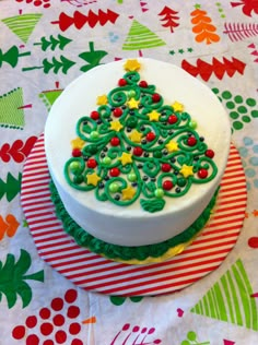 a decorated christmas cake sitting on top of a red and white plate with green icing