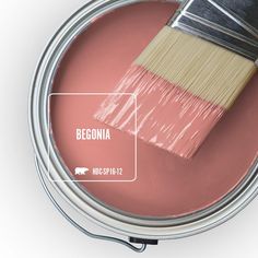 a pink paint can with a brush in it