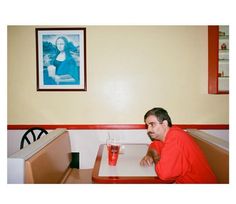 a man sitting at a table with a drink in front of him