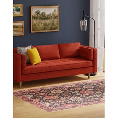 a living room with blue walls and a red couch in front of a painting on the wall