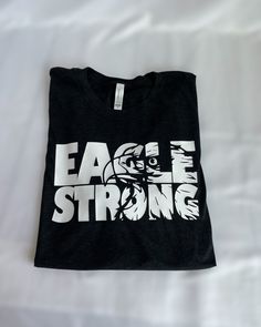 Show off your eagle pride with our Eagle Strong T-shirt, perfect for any die-hard Avon fan. Made of a soft blended fabric, you'll feel like an eagle soaring through the sky when you wear it! Looking for something extra cozy? We also have hoodies and crewneck sweatshirts--just shoot us a message! Eagles Shirt Ideas, Eagles School Shirt, Homecoming Shirts, Friday Night Lights Shirt, Basketball Shirt Designs, Eagle Soaring, Shirt Crafts, Booster Club, Cheer Shirt