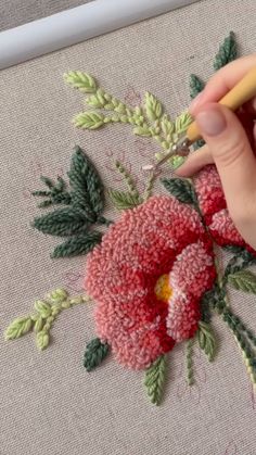 someone is working on an embroidered flower