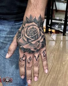 a man's hand with a rose on it and the word love written in black ink