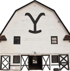 an old white barn with the letter y painted on it