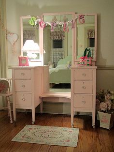 there is a pink vanity and mirror in this room with flowers on the floor next to it