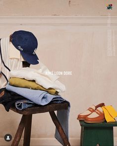 a person sitting on a stool next to a pile of clothes and shoes with the caption ame leon dore