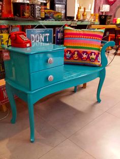 a blue table with a sign on it and a red phone sitting on top of it