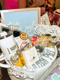 a white basket filled with lots of different types of items next to a sign that says happy birthday