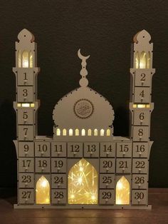 a lit up clock tower on top of a wooden table