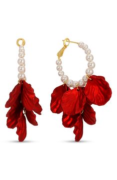 a pair of red leaves and pearls are hanging from the hoops on white background