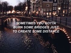 a bridge that has some lights on it with the words sometimes you gota burn some bridges just to create some distance