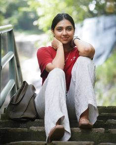 a woman sitting on steps with her legs crossed