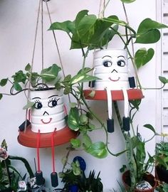 two plant pots with faces hanging from them