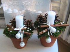 two small pots with candles and decorations on them