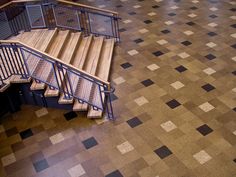 an overhead view of a stair case in a building with tiled flooring and blue railings