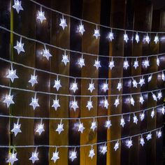 white star lights are strung on a wooden fence