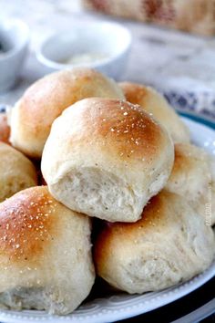 rolls piled on top of each other on a plate with dipping sauces in the background