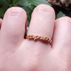 a person's hand with a gold ring that says explore on it