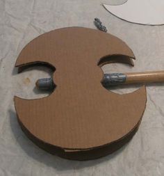 a cardboard smiley face with a pencil sticking out of it's hole in the middle