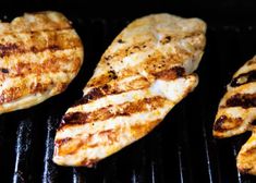 three pieces of chicken cooking on a grill