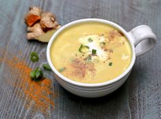 a white bowl filled with soup next to some vegetables