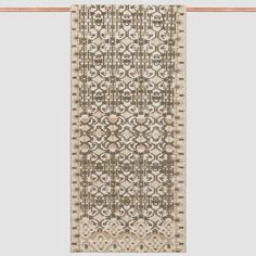 a beige and brown rug hanging on a wall