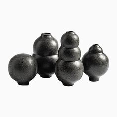 four black vases sitting next to each other