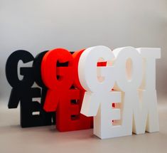 three different colored letters sitting next to each other on a white surface with the word go me spelled in black and red