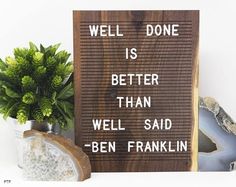 a wooden sign that says well done is better than well said - ben franklin