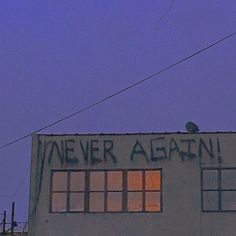 an old building with graffiti written on it's side and the sky in the background