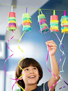 a young boy holding up some colorful streamers