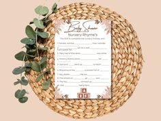 a baby shower game in a basket with eucalyptus leaves around it on a pink background