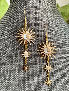 Inspired by Astoria, the Greek Goddess of stars, comes these stunning sun and star earrings. These earrings would make a great addition to a Greek Goddess Halloween costume or for anyone who loves moon and star jewelry as much as I do. The earrings feature a golden sun, with a small white moon in its center, and two 8-pointed starts delicately dangling from the sun all on a 14k gold plated earring hook.  *Only one in stock at this time but more to come based on customer demands.* Celestial Moon-shaped Earrings With Star Charm, Celestial Moon Earrings With Star Charm, Celestial Moon Shaped Earrings With Star Charm, Mystical Gold Earrings With Sun And Moon Design, Mystical Sun And Moon Earrings As Gift, Celestial Star-shaped Pierced Earrings, Celestial Sun Design Dangle Jewelry, Gold Celestial Earrings With Sun Design, Celestial Star-shaped Earrings With Sun And Moon Design