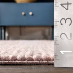 a close up of a bed with a measuring tape on the floor next to it