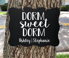 a sign hanging from the side of a tree that says, dorm sweet dorm ashley stephanie