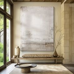 a living room with a large painting on the wall and two vases next to it