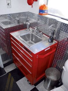 a red sink and cabinet in a small room