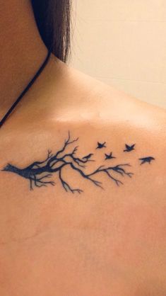 a woman with a tree branch tattoo on her back shoulder and birds flying around it