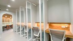 a row of office chairs sitting next to each other in front of a wall with glass partitions