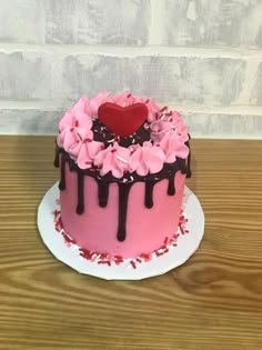 a heart shaped cake with pink frosting and sprinkles