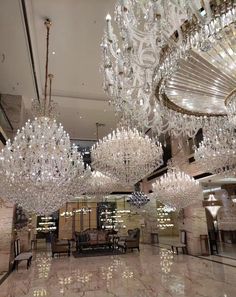 a large chandelier hanging from the ceiling in a room filled with tables and chairs