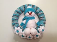 a crocheted snowman ornament hanging on a wall