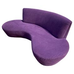 a large purple couch sitting on top of a white floor