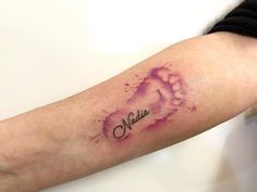 a woman's arm with a watercolor tattoo on it