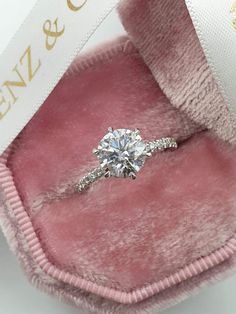 an engagement ring in a pink velvet box