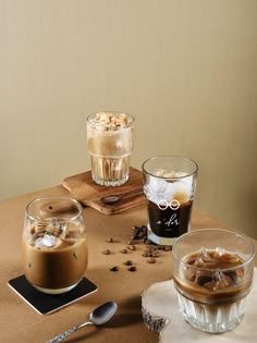 there are two glasses of coffee on the table next to each other with ice and nuts in them