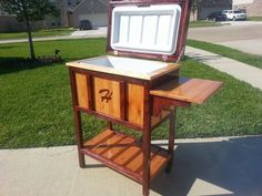 an old wooden table with a cooler on it