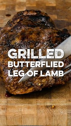 a piece of meat on a cutting board with the words grilled butterflied leg of lamb