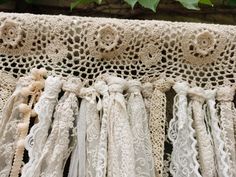 several pieces of crocheted lace hanging from a tree